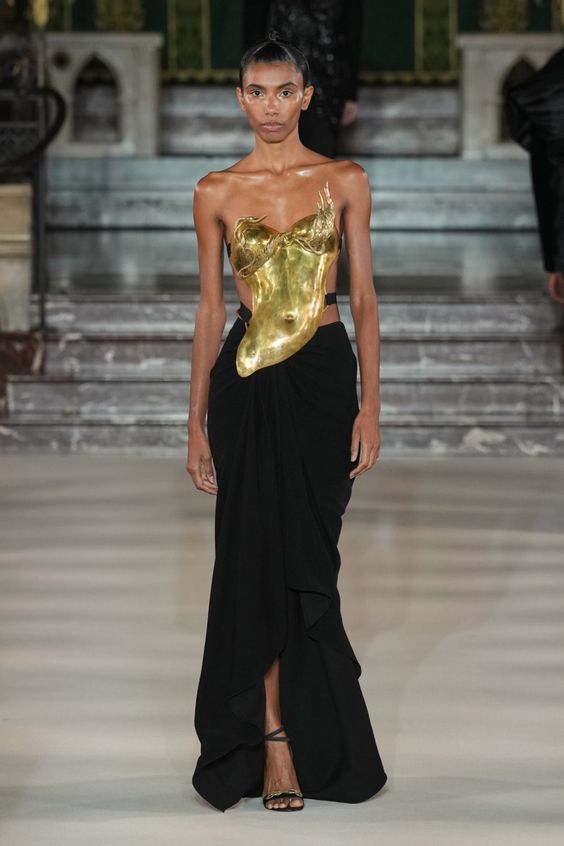 Gold sculture looking top worn with black maxi shirt.